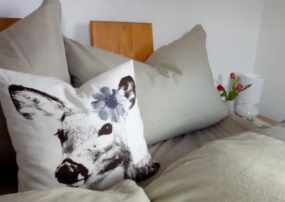 Deko-Kissen mit Reh-Motiv auf dem Bett im Chalet Schwarzwald Lindenbuch.