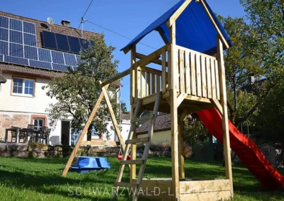 Spielplatz mit Kletterturm und Rutsche im Garten des Chalet Schwarzwald.