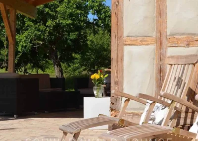 Gemütliche Terrasse mit Holzliegestühlen am Fachwerk des Chalet Schwarzwald Ferienhaus Lindenbuch.