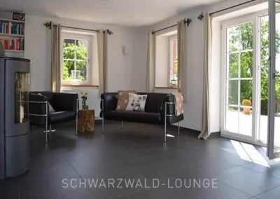 Helle Sitzecke im Chalet Schwarzwald mit Lederstühlen und direktem Zugang zur Terrasse im Ferienhaus Lindenbuch.