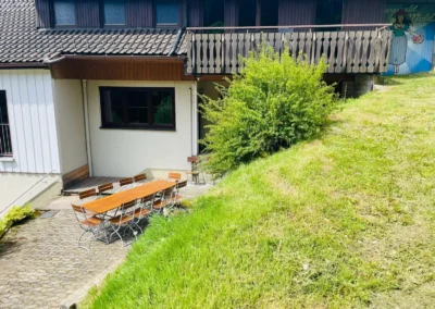 Große Terrasse mit langer Sitzgruppe vor dem Ferienhaus Hof Busems im Schwarzwald.