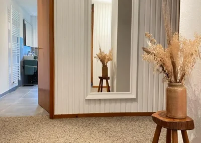 Dekorativer Vorraum mit Wandspiegel und Trockenblumen im Ferienhaus Hof Busems im Schwarzwald.