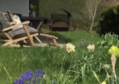 Blumenreicher Garten der Ferienwohnung Kinzigtal mit Liegestuhl und Terrasse