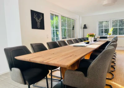 Modernes Esszimmer im Schwarzwald Chalet Lohmühle mit Designstühlen und langem Holztisch.