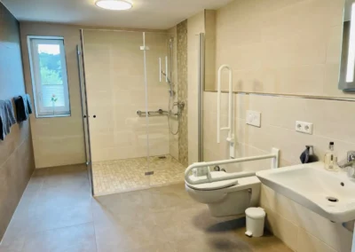 Modernes Badezimmer der Ferienwohnung Westweg mit großer Dusche und stilvollen Fliesen.