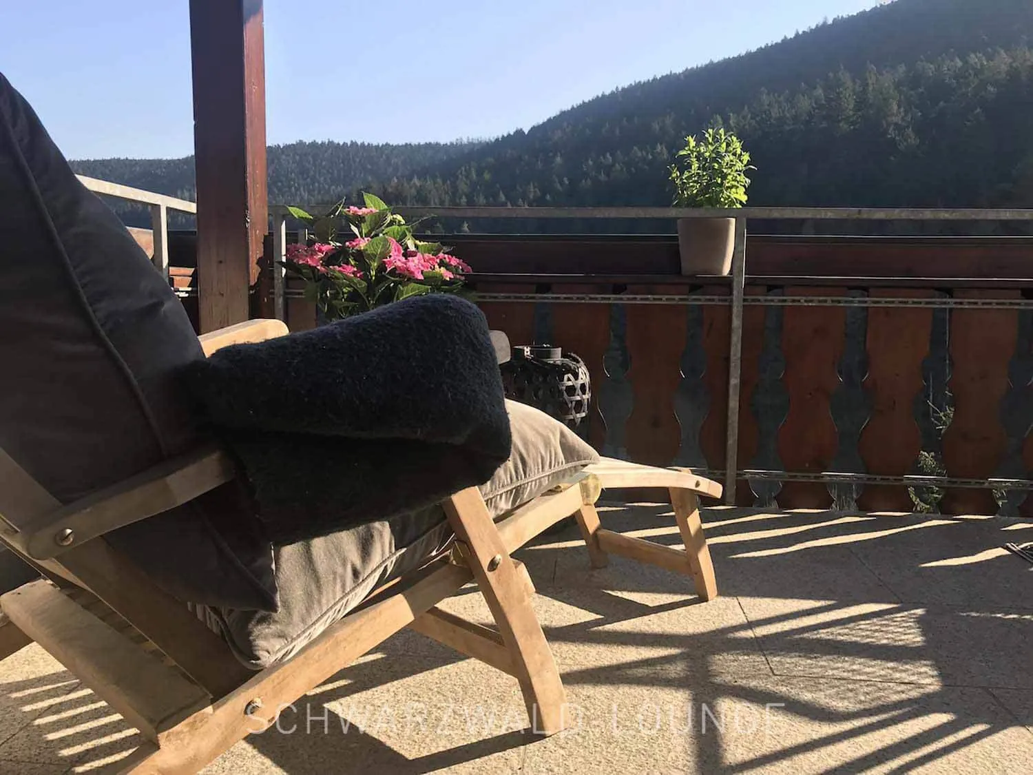 Liegestuhl auf dem Balkon der Ferienwohnung Bergsee mit Blick auf den Schwarzwald.