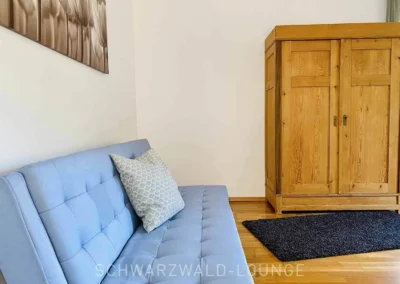 Großes Schlafzimmer der Ferienwohnung Bergsee im Schwarzwald mit Schlafcouch und Kleiderschrank.