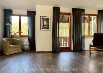 Großzügiges Wohnzimmer mit direktem Zugang zum Balkon in der Ferienwohnung Bergsee Schwarzwald.