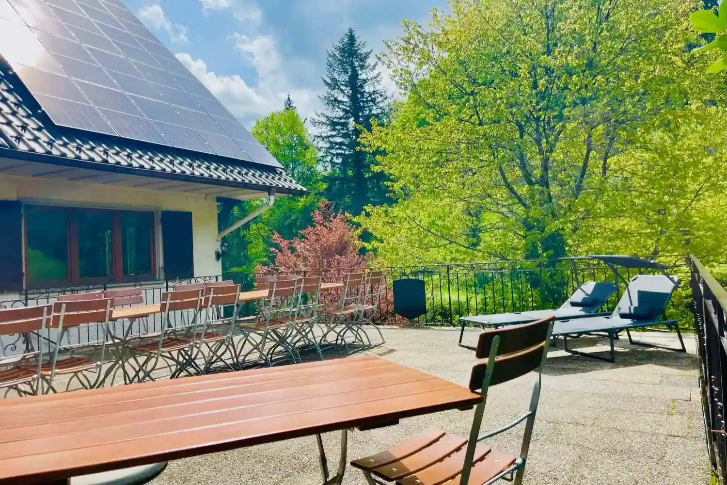 gruppenunterkunft-schwarzwald-sonnenterrasse-liegen-sitzplaetze-schwarzwaldlounge Große Sonnenterrasse der Gruppenunterkunft Schwarzwald mit Liegen und langer Sitztafel.