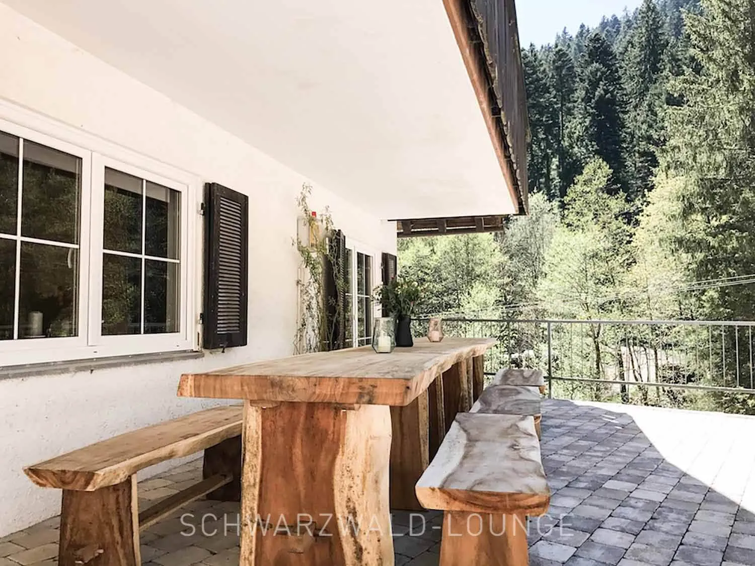 Schwarzwald Chalet Lohmühle – Terrasse mit Holztisch & Naturblick Schwarzwald Chalet Lohmühle – massive Holzbänke und großer Tisch auf der Terrasse am Waldrand.