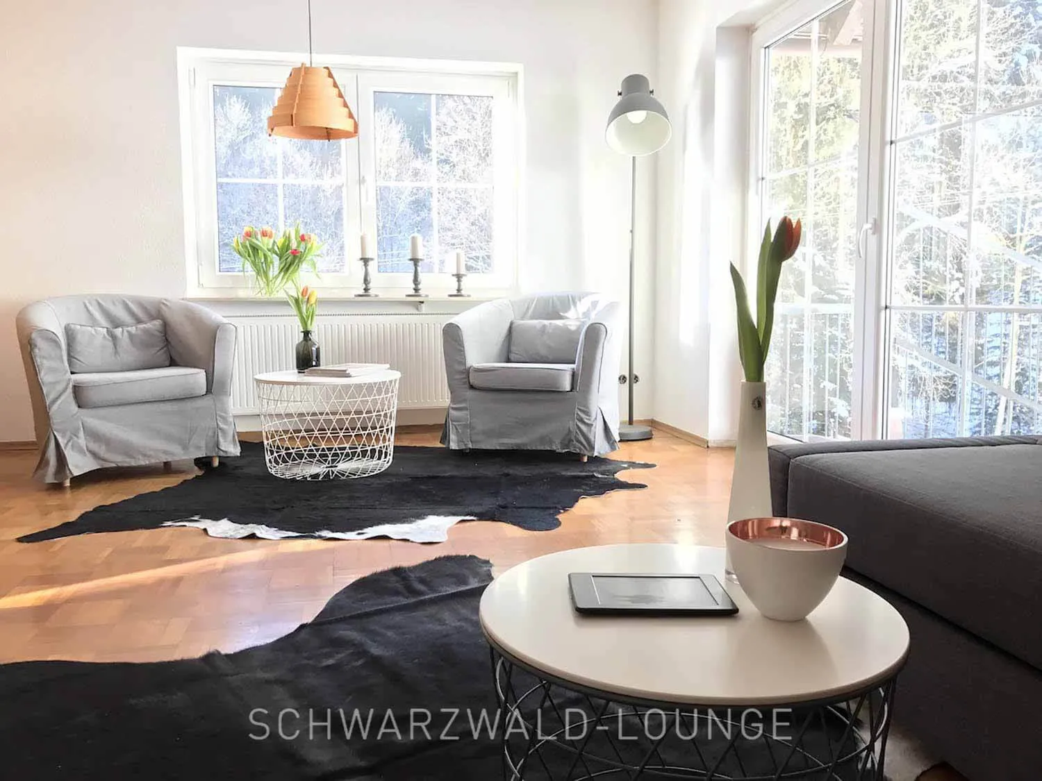 Schwarzwald Chalet Lohmühle – Sessel im Schlafzimmer unten Gemütlicher grauer Sessel mit Dekokissen im unteren Schlafzimmer des Schwarzwald Chalet Lohmühle.