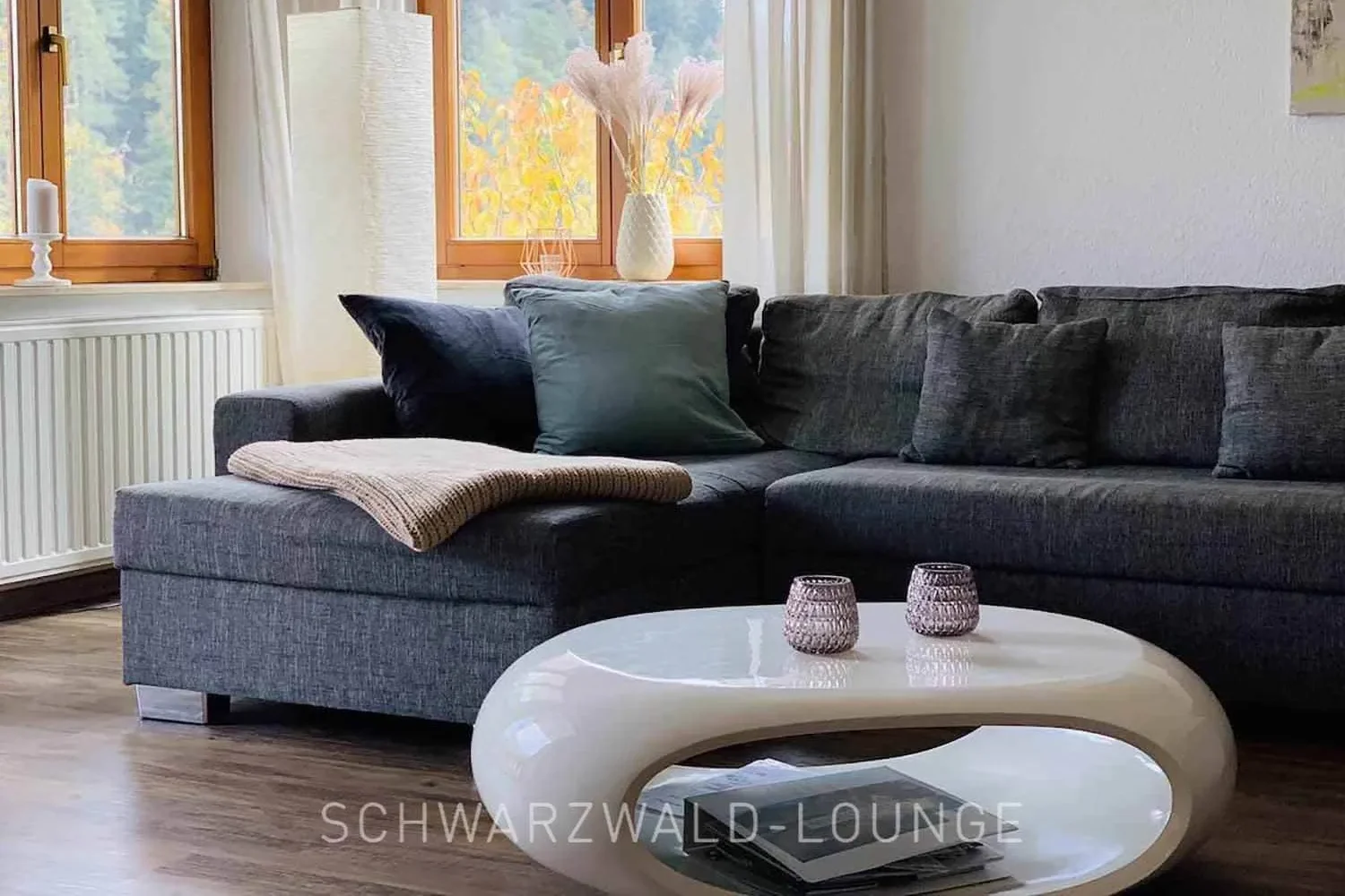 Waldwiese – Modernes Wohnzimmer mit Ecksofa Wohnzimmer der Ferienwohnung Waldwiese mit modernem Ecksofa und stilvollen Wohnaccessoires.