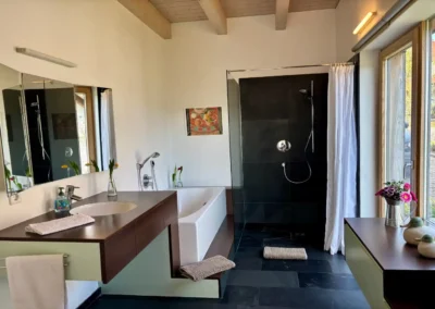 Badezimmer im Ferienhaus Baiersbronn Weitblick mit Dusche, Badewanne und Fenster