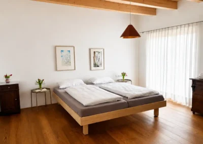 Schlafzimmer im Ferienhaus Baiersbronn Weitblick mit Doppelbett und Holzboden