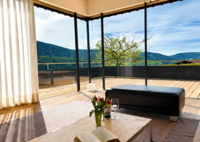 Wohnbereich im Ferienhaus Baiersbronn Weitblick mit großer Glasfront und Terrassenblick