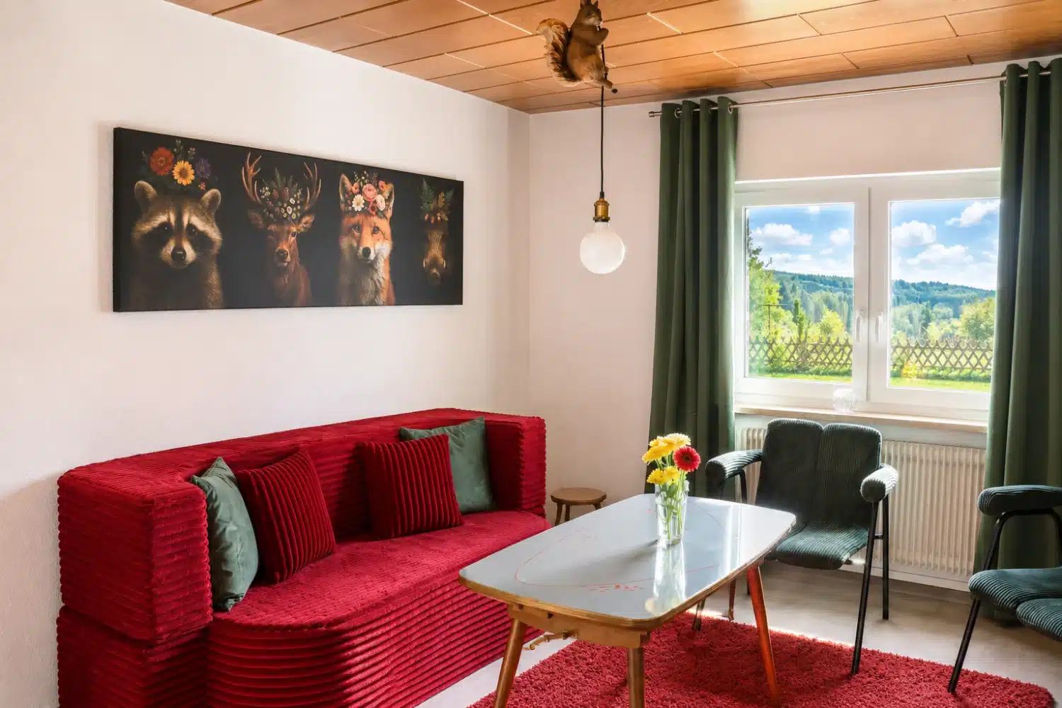 Aufenthaltsraum im Ferienhaus Tanne und Tal Relax mit rotem Sofa, Sesseln und Blick in den Schwarzwald Aufenthaltsraum im Ferienhaus Tanne und Tal Relax mit rotem Sofa, Sesseln und Blick in den Schwarzwald