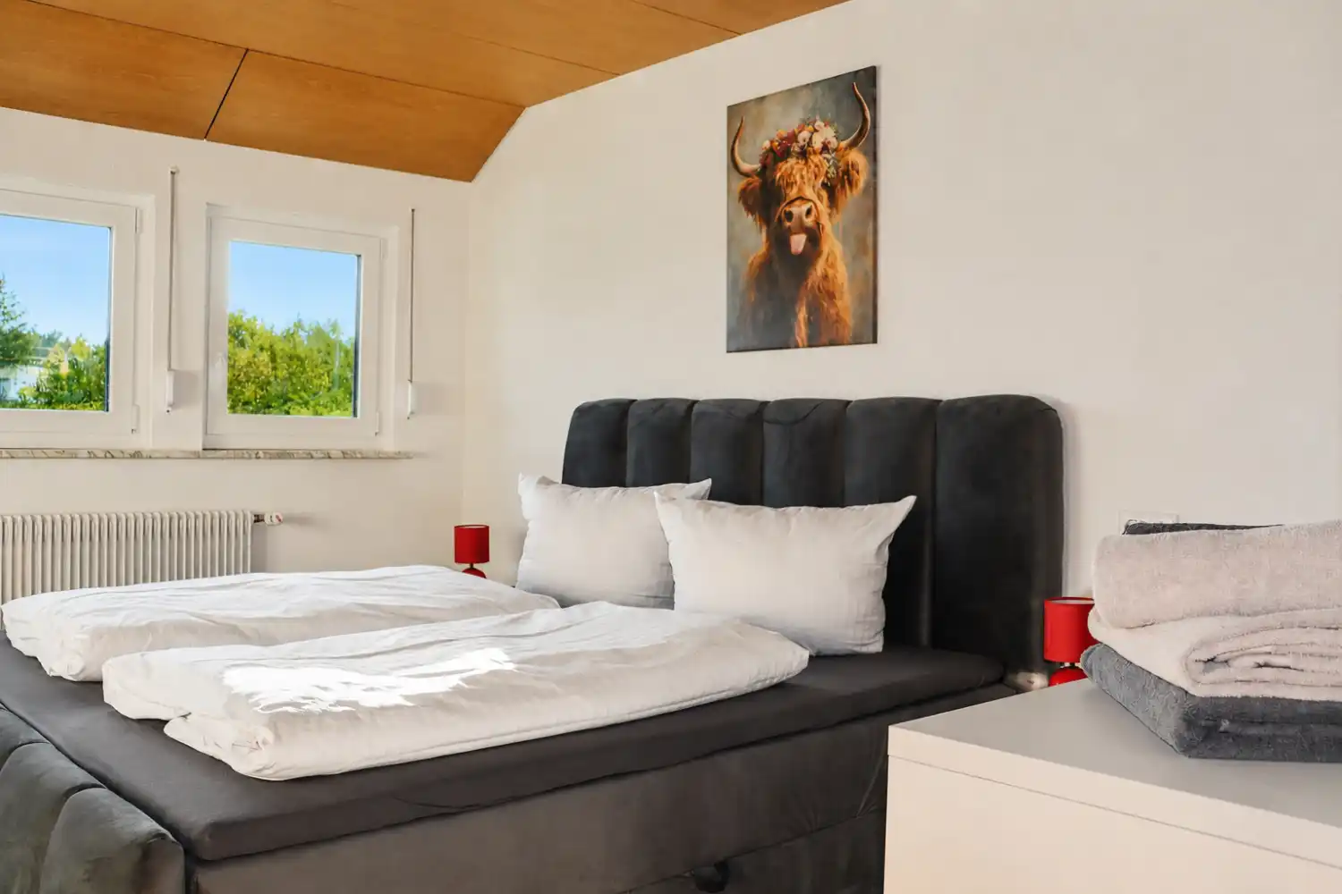 tanne-und-tal-relax-schlafzimmer-doppelbett-naturblick-schwarzwald-lounge Modernes Schlafzimmer mit Doppelbett, Stauraum, Garderobe und dekorativen Wandbildern im Ferienhaus Tanne und Tal Relax im Schwarzwald.